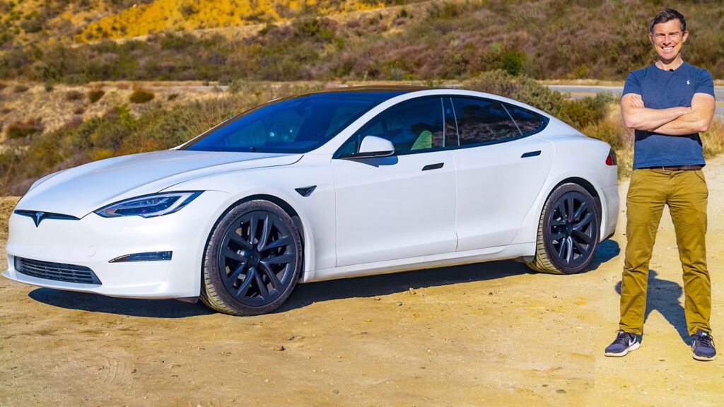 man standing beside tesla